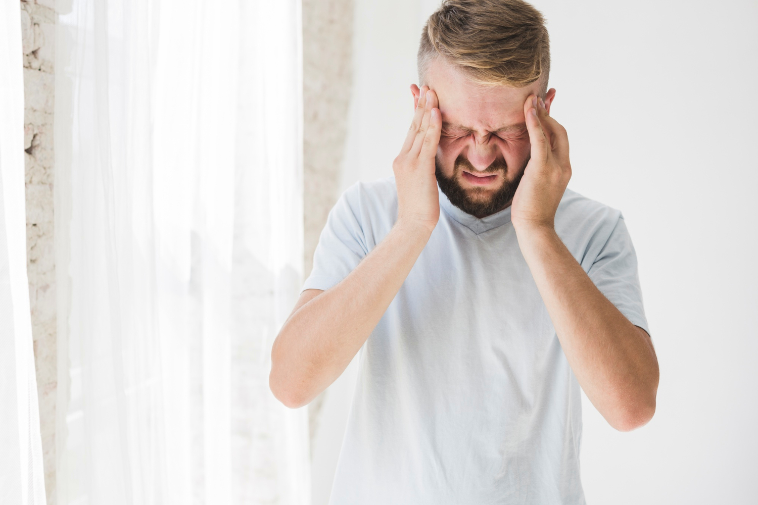 persona che stringe le tempie in preda al mal di testa